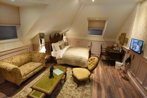 伯明翰The Aston Tavern的一间卧室配有一张床、一张沙发和一张桌子