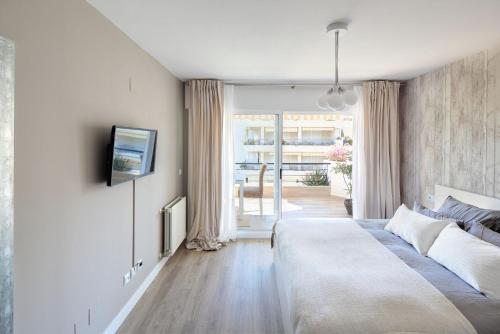 马贝拉Fantastic Apartment Next To Guadalmina Golf Course In Marbella的一间卧室配有一张床,墙上配有电视