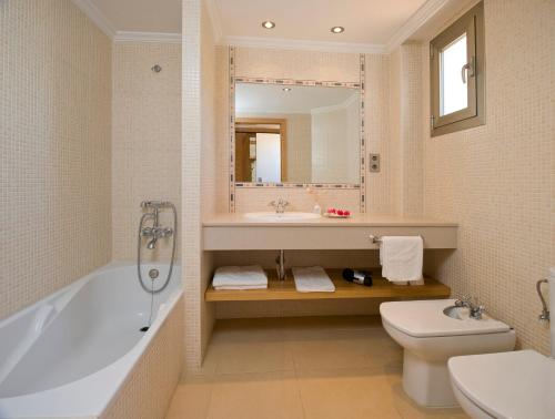 普拉亚登博萨Bon Sol Prestige - AB Group的带浴缸、盥洗盆和卫生间的浴室