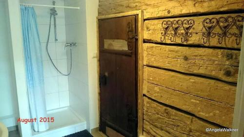 KrisplSchnaitstadl-Alm的一间带木门和淋浴的浴室