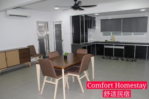 麻坡Muar Homestay (Comfort Homestay)的一间厨房,内设一张木桌和椅子