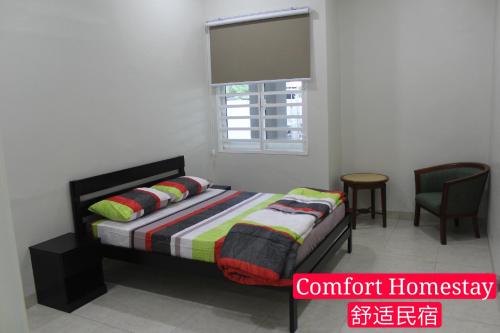 麻坡Muar Homestay (Comfort Homestay)的一间卧室配有一张带窗户和椅子的床