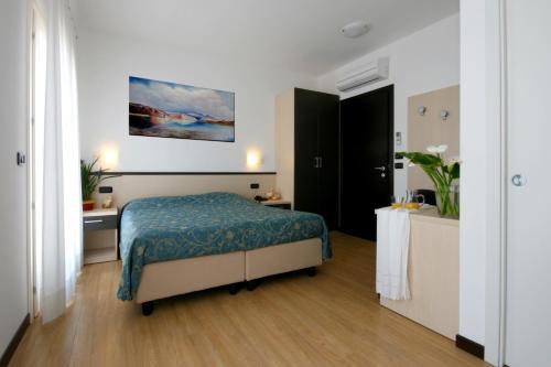 Bevazzana阿尔弗格酒店的一间卧室配有一张带蓝色毯子的床