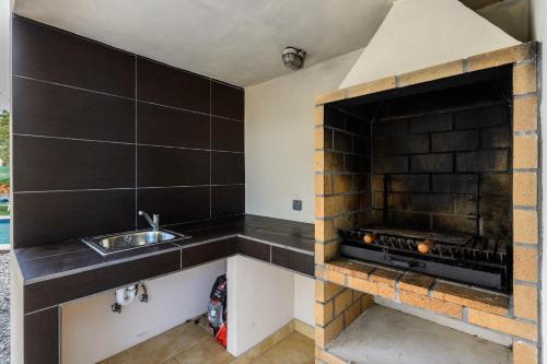 伊斯费古耶拉尔海滩Villa Aigües Blanques的一个带水槽和壁炉的厨房