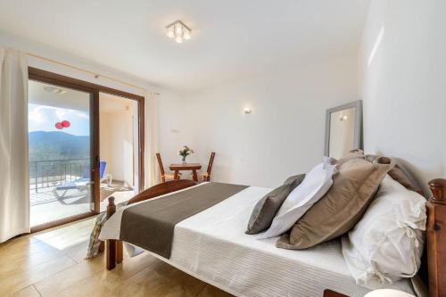 伊斯费古耶拉尔海滩Villa Aigües Blanques的一间卧室设有一张床,享有阳台的景色