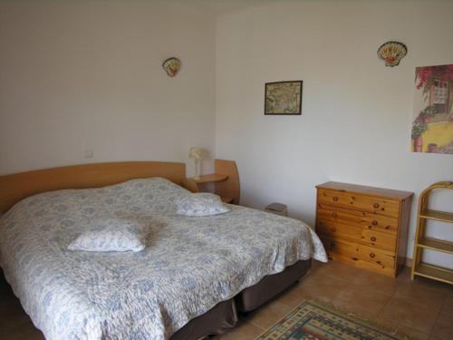 拉戈斯Casa da Praia para férias - Vila Pinheiro - Vivenda Johanna的一间卧室配有带2个枕头和梳妆台的床
