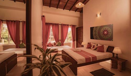 尼甘布Bohemian Hotel - Negombo的一间卧室设有两张床,里面种有植物