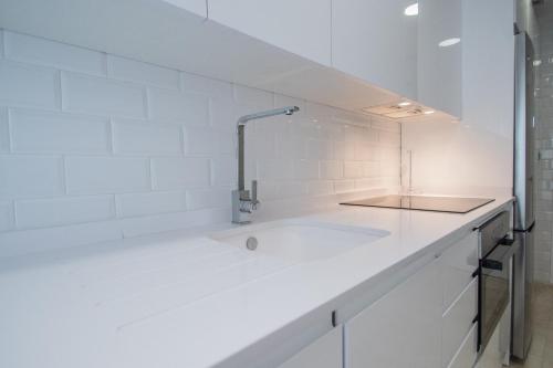 加的斯Apartamento Sueño de la Caleta的白色的厨房设有水槽和台面