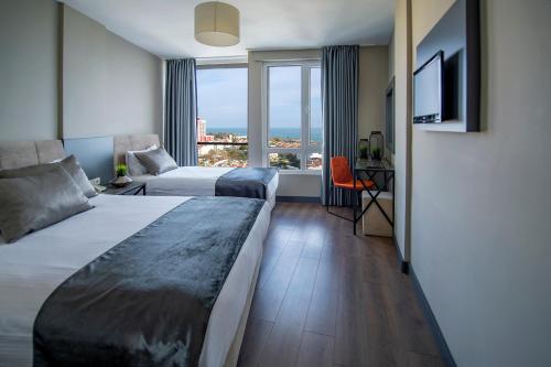 安塔利亚Tourist Hotel的酒店客房设有两张床和窗户。