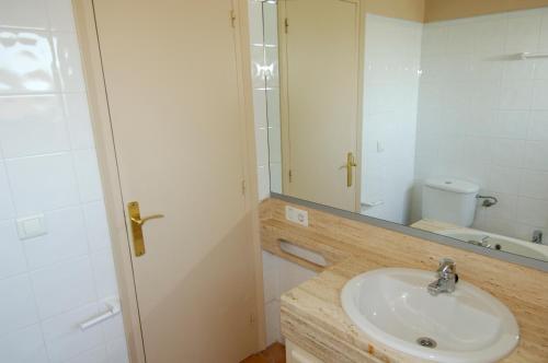卡莱利亚德帕拉弗鲁赫尔Apartaments prat xirlo的一间带水槽、镜子和卫生间的浴室