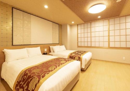 东京Arakawa-ku - Hotel / Vacation STAY 22245的客房设有两张床和大屏幕