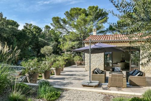 阿维尼翁新城La Villa Dupont d'Avignon的一个带遮阳伞和椅子及树木的庭院