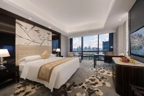 深圳深圳华强广场酒店 - 住客尊享免费欢乐下午茶&迷你吧&宵夜 的酒店客房设有一张床、一张书桌和一个大窗户。