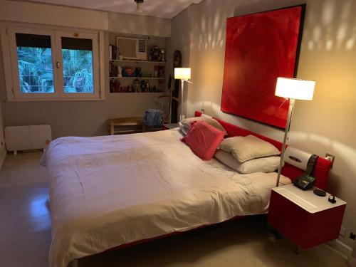 圣伊西德罗Deaf twins bed/breakfast的卧室配有一张大床,墙上挂有红色的画作