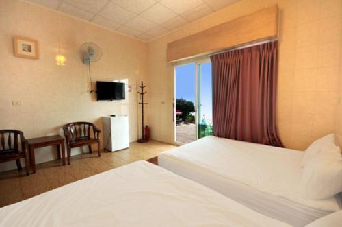 小琉球岛蓝色海湾的酒店客房设有两张床和窗户。