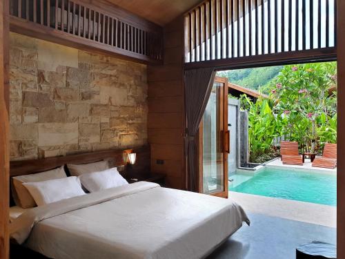 龙目岛库塔Batatu Villas的一间卧室设有一张床和一个游泳池