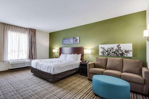 育空Sleep Inn & Suites Yukon Oklahoma City的酒店客房,配有床和沙发