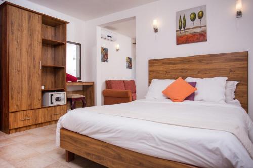 蓝海湾Talamba Blue的一间卧室配有一张大床和木制床头板