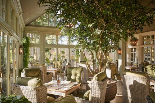 奥赫特拉德Cairn Lodge的一间设有桌椅的餐厅,还有一棵树