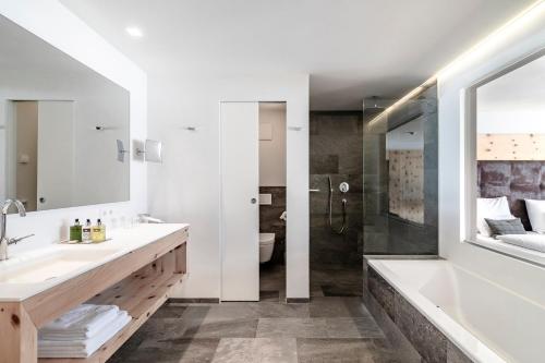 阿尔卑斯休斯山阳光运动酒店的带浴缸、水槽和淋浴的浴室
