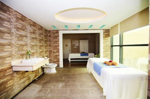 清化孟青大清化酒店的一间带两张床、浴缸和水槽的浴室