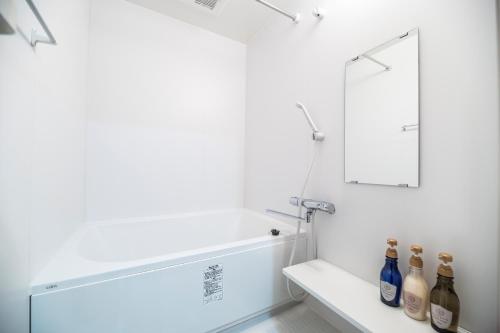 京都京宿伊吕波东寺本馆公寓式酒店的浴室拥有白色的墙壁、镜子和瓶子