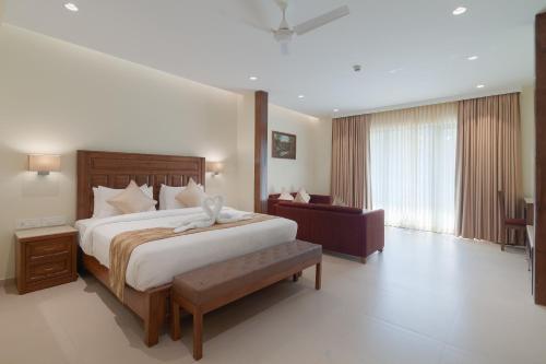 坎多林Seashell Suites and Villas- Candolim Goa的一间卧室配有一张床和一个沙发