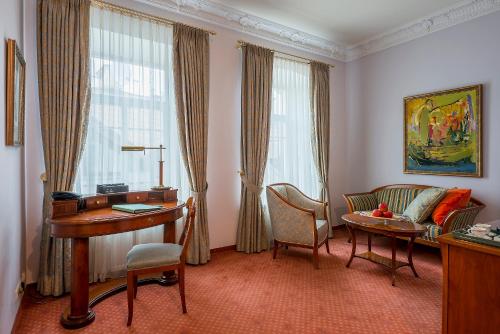 维尔纽斯Grotthuss Boutique Hotel Vilnius的客厅配有书桌、沙发和桌子