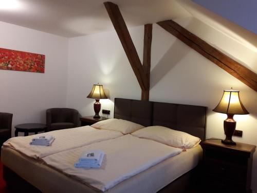 新比斯特日采福格酒店的一间卧室配有一张床,上面有两条毛巾