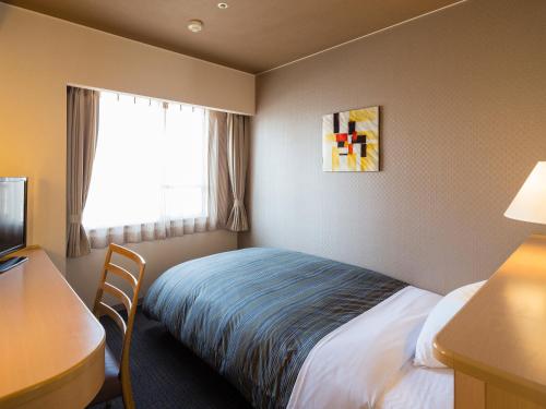 姬路胜别姬路城堡酒店的配有一张床、一张书桌和一扇窗户的酒店客房