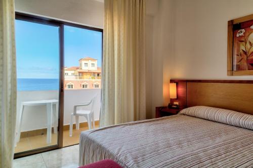 拉克鲁斯马尔科萨酒店的一间卧室配有一张床,享有海景