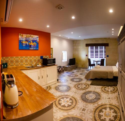 拉巴特Casa Azzopardi Guesthouse的一间设有一张床的大房间和一间带桌子的房间