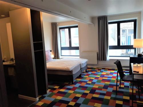 布鲁塞尔凡其酒店的一间卧室配有床和色彩缤纷的地毯
