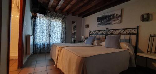 托莱多拉坡萨达得可多维旅馆的一间卧室设有两张床和窗户。