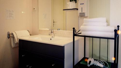 莫尔莱The Originals City, Hôtel Fontaine, Morlaix的浴室配有盥洗盆、镜子和毛巾