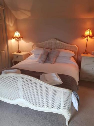 TopcliffeThe Swan的卧室内的一张白色床,配有两盏灯