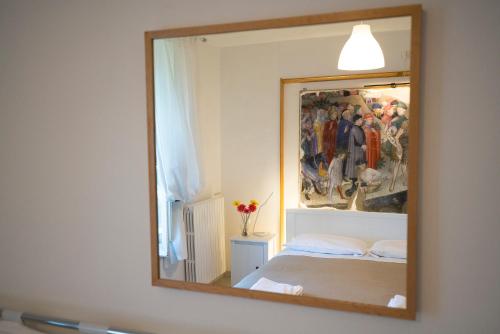乌尔比诺B&B Aquilone的镜子在床上方的墙上