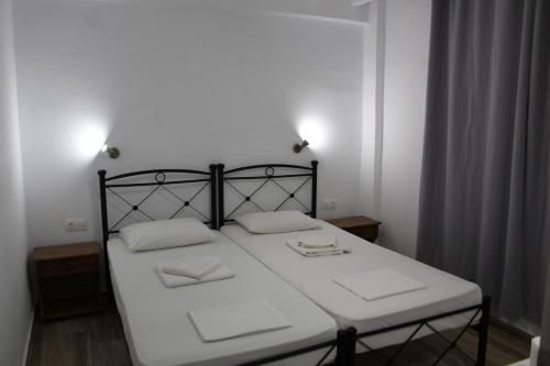 伊莱恩Zeus Hotel的一间卧室配有一张带两个白色枕头的床