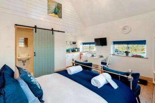 梅德斯通The Annexe with Hot Tub的一间卧室配有一张带蓝色枕头的大床