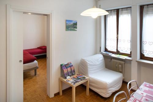 贝卢诺卡萨费南达公寓的一间设有白色椅子和一张桌子的房间