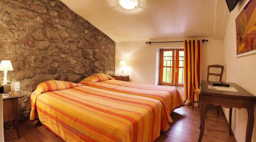 杜尔哈克老磨坊旅馆的一间卧室设有一张床和石墙