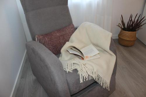 维塞乌Vigia's Guest House的椅子上的毯子,上面有一本书