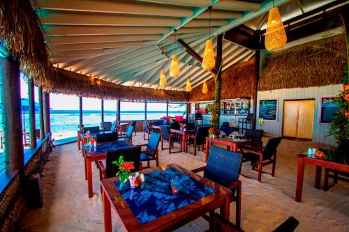拉罗汤加马努娅海滩度假村的海滩上的餐厅,配有桌椅
