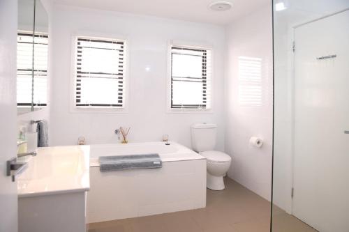 Clareville皮特沃特瑞弗吉科夫公寓的白色的浴室设有浴缸和卫生间。