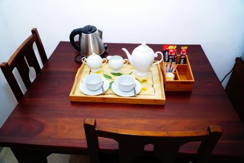 卡图纳耶克Airport 4 Season Transit Hotel的一张木桌,上面放着茶具