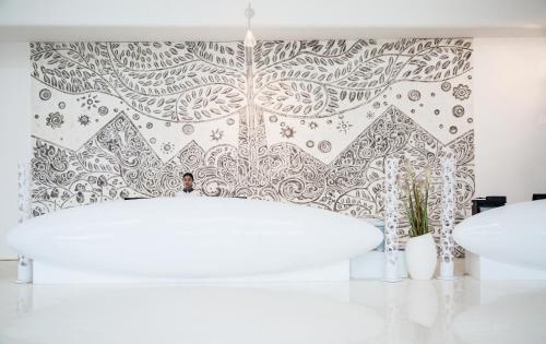 三亚三亚湾红树林度假世界椰林酒店的浴室设有白色浴缸和带图案的墙壁