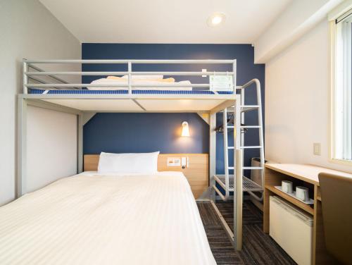 十和田Super Hotel Towada Natural Hot Springs的小房间设有双层床和书桌