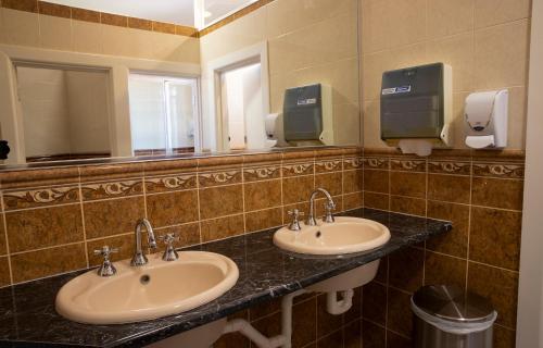冈德盖Criterion Hotel Gundagai的浴室设有2个水槽和镜子