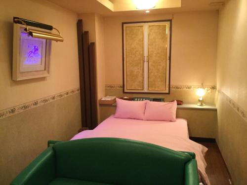 大阪Dear Place(Adult Only)的小房间设有一张床和一把绿色椅子