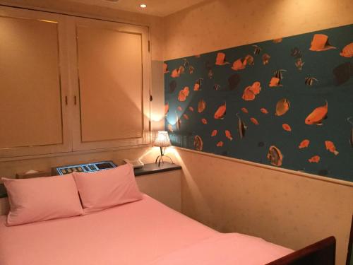 大阪Dear Place(Adult Only)的一间卧室设有一张床,墙上有橙色的叶子
